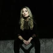 Anna Eriksson istuu mustissa vaatteissa betonilla