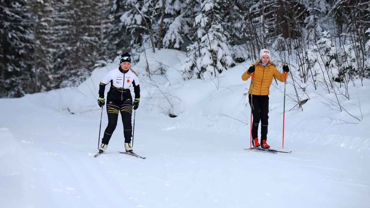 Savonlinnan hiihtoseuran Netta Tuhkanen (vasemmalla) hiihtää ampumahiihtoa harrastavan Anni Saksmanin kanssa Savonlinnan Aholahdessa.