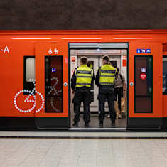 Photo shows two security guards on a Helsinki metro.