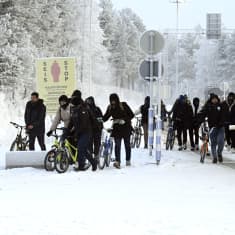 Turvapaikan hakijoita saapuu polkupyörillä rajanylityspaikalle Sallassa.