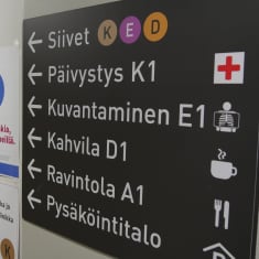Opasteet Etelä-Karjalan keskussairaalan seinällä.