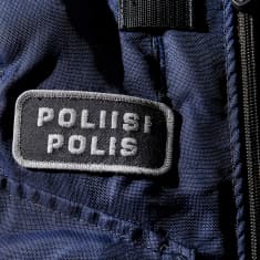 Yksityiskohta poliisin sinisessä virkapuvussa.