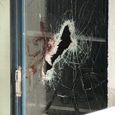 Rikkinäinen ja verinen rappukäytävän ulko-ovi Forssassa.