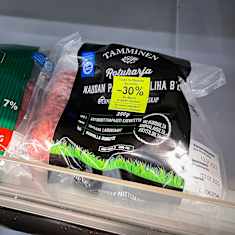 Discount-stickered meat packages on a shop shelf. 