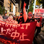 Ihmiset osoittovat mieltä Tokion olympiakisoja vastaan Tokiossa 17.3. 