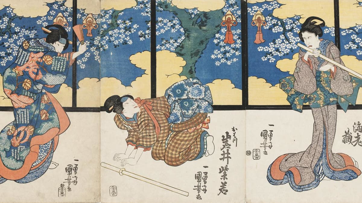 Kolme naista värikkään seinän edessä kabuki-näytelmässä.