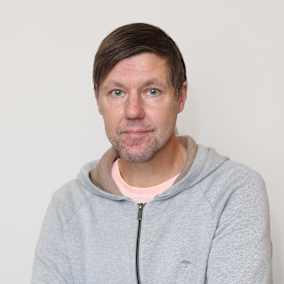 Toimittaja Tero Valtanen seisuu käden puuskassa harmaassa hupparissa. 