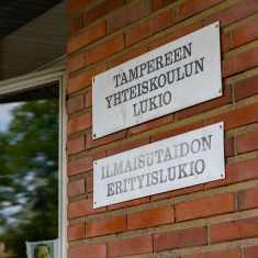 Tampereen yhteiskoulun lukion kyltti rakennuksen seinässä.