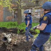 Pelastushenkilöt poistavat raketin jäännöksiä maasta.