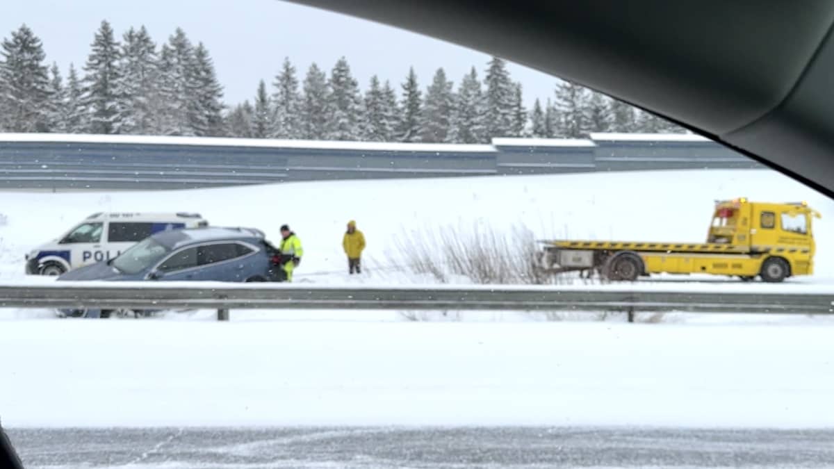 Auto ojassa, poliisi ja hinausauto paikalla Oulun moottoritiellä.