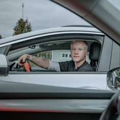 17-vuotias Aatu Marttila istuu autossaan parkkipaikalla.