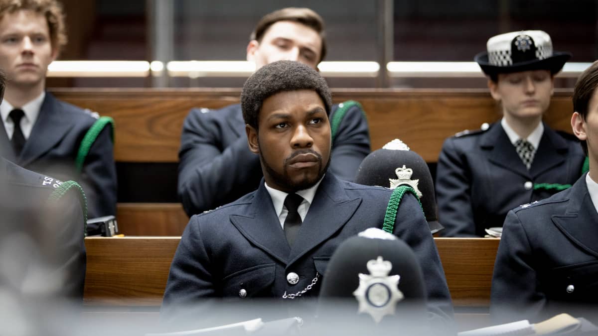 Konstaapeli Leroy Logan (John Boyega) istuu uniformupukuisena muiden poliisien joukossa luentosalissa. Kuva elokuvasta Small Axe: Red, White and Blue