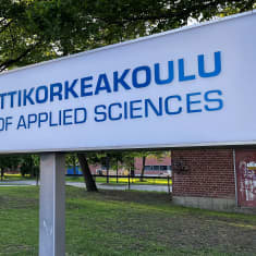 Hämeen ammattikorkeakoulun kyltti pihamaalla.