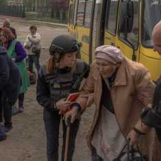 Evakuoitavia vanhuksia saatetaan bussilta Harkovan alueella.