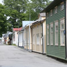 En gata med gamla trähus i olika färger.