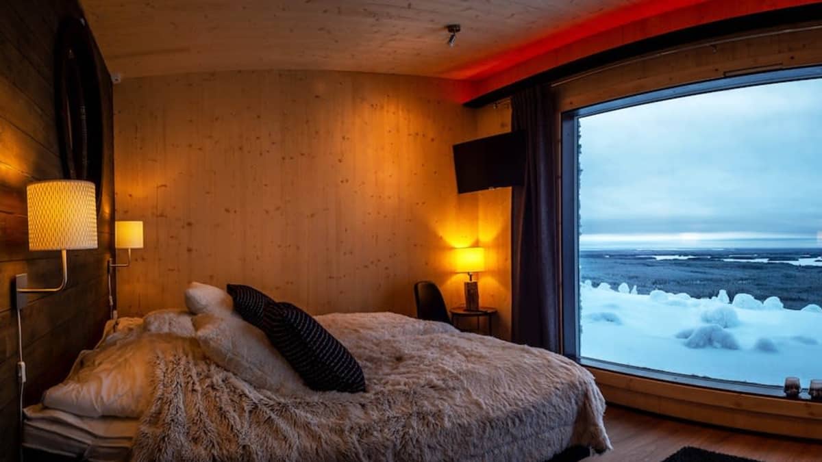 Huoneen ikkunasta näkyy luminen maisema.
