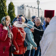 Ortodoksipappi siunaa seurakuntalaisia Harkovassa.
