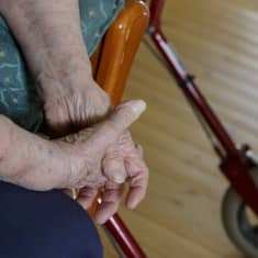 Kuva vanhan naisen käsistä ristissä.