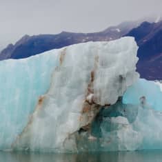 Jäätiköstä irronnut jäälohkare kelluu vedessä.