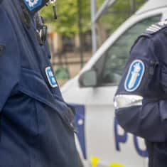 Kaksi poliisia tunnitamattomassa lähikuvassa. Poliisin hihamerkit näkyvillä.