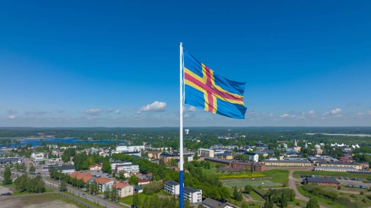 Maailman suurin Ahvenanmaan lippu nostettiin jättitankoon Haminassa –  liehuu juhlavuoden huipentumisen kunniaksi