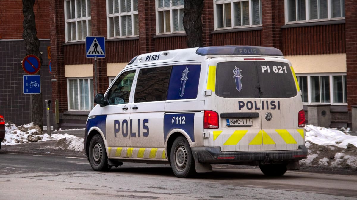 Poliisiauto liikkeellä Tampereen kadulla. Ympäristö on likaisen luminen, kuten hieman itse autokin.