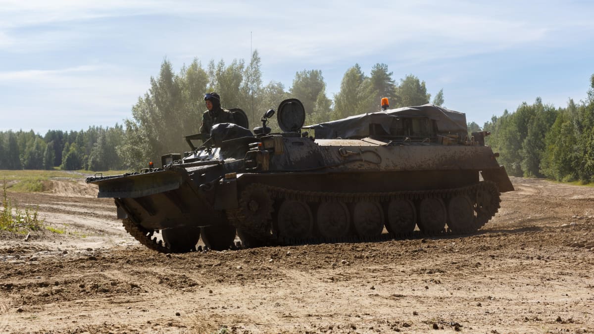 Puolustusvoimien aseistamaton MT-LB tela-alustainen panssaroitu ajoneuvo ajamassa hiekkatiellä.