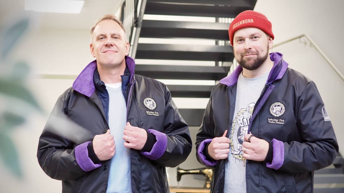Niklas Törn ja Teemu Artukka musta-violetit TPS-logolla varustetut kansitakit päällä portaikon edessä.