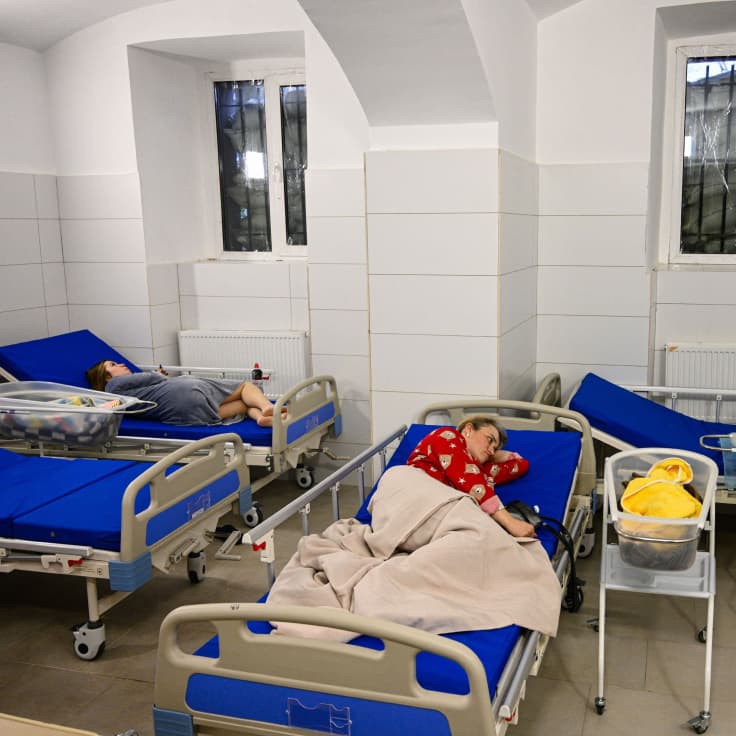 äitejä ja vauvoja sairaalassa sängyillään ilmahälytyksen aikana