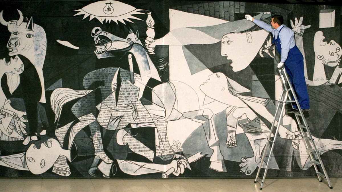 Mies tikapuilla huoltaa(?) Picasson Guernica-maalausta.