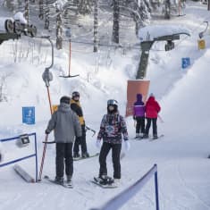 Ihmisiä nousemassa hissiin.