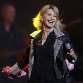 Olivia Newton-John esiintyy konserttilavalla.