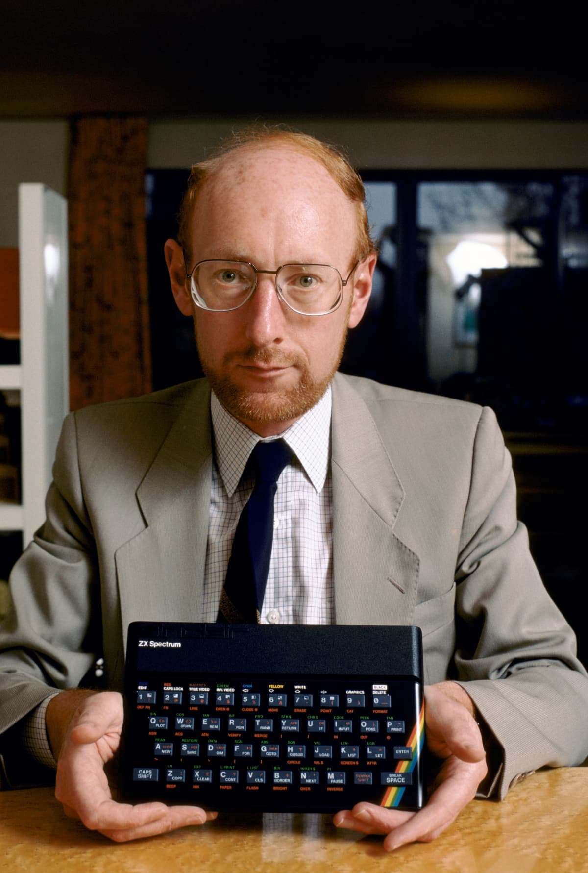 Clive Sinclair pitää kädessään Sinclair ZX Spectrum -mikrotietokonetta.