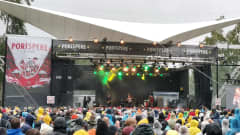 Sadevaatteisiin sonnaustunutta yleisöä pakkaantuneena esiintymislavan eteen Porispere-fetivaalilla Porin Kirjurinluodossa.