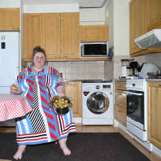 Iiu Susiraja istuu keittiössä perunakattila kädessään.