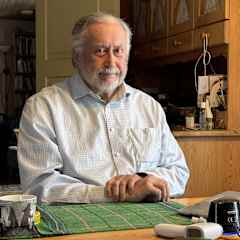 Pekka Sammallahti katsoo suoraan kameraan työpöydän äärellä Utsjoen Vetsikossa.