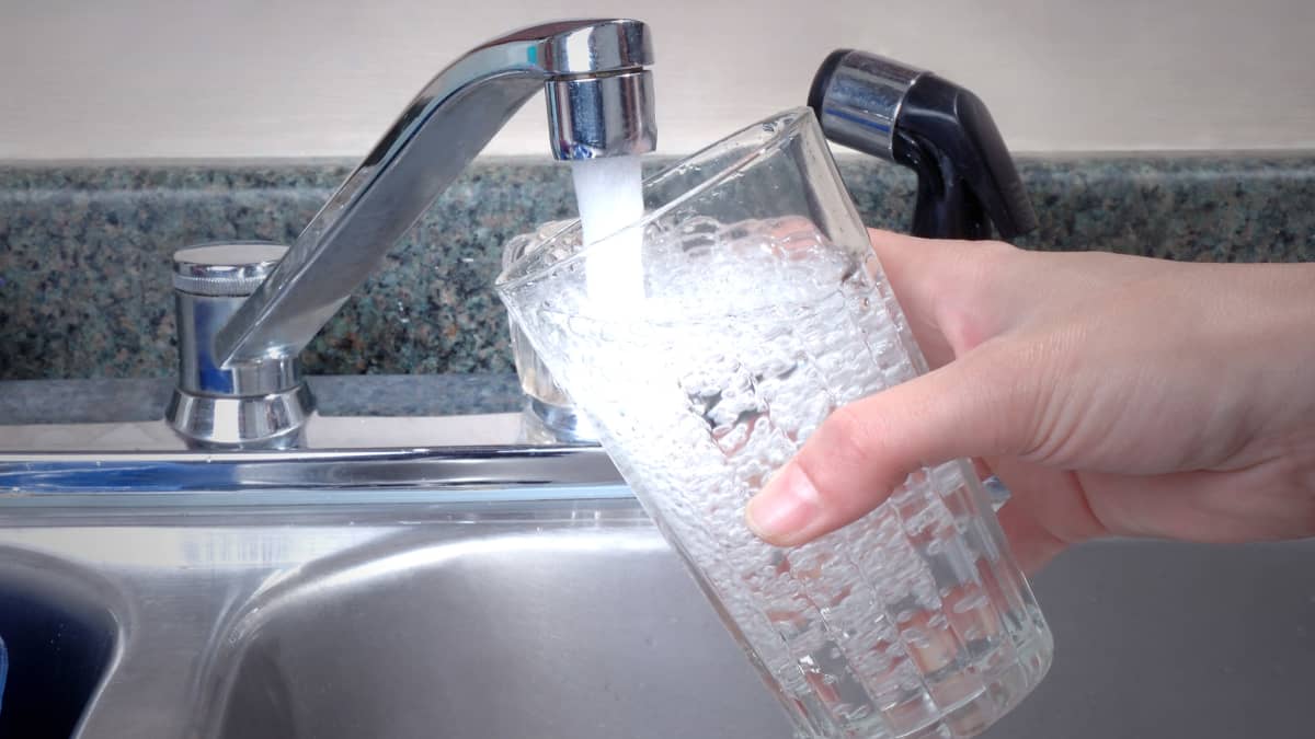 Människa tappar dricksvatten i glas