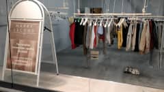 Vaatteita roikkuu rekeissä käytettyihin vaatteisiin erikoistuneessa myymälässä.