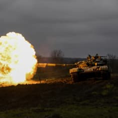 Ukrainan armeijan tankki ampuu tykillä. Suuliekki valaiseen maiseman.