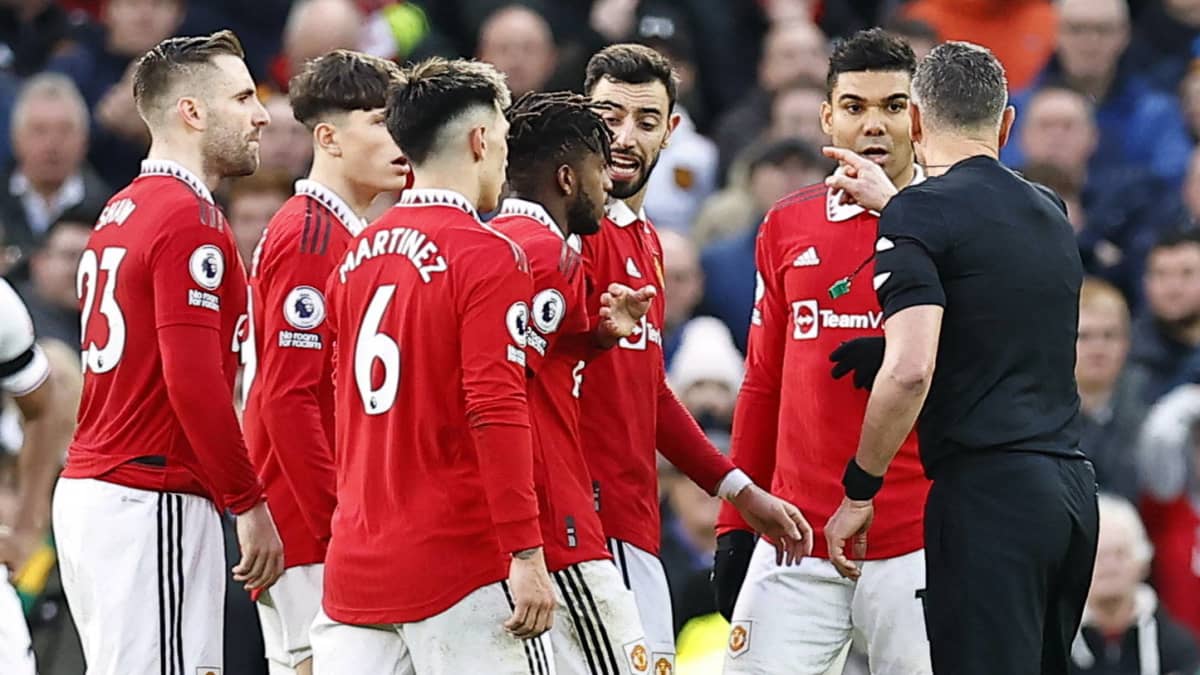 Manchester United keskustelee tuomarin kanssa. 