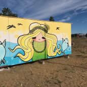 Inna Pulkkisen eli Poppamaijan tekemä graffiti, jossa vaaleahiuksisen tytön molemmilla puolilla ovat saimaannorpat.