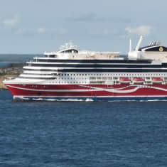 Viking Linen punavalkoinen Glory-alus Maarianhaminan lähivesillä, poutainen sinitaivas, meri ja saaristomaisemaa.