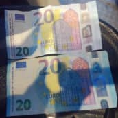 Kaksi kahdenkymmenen euron seteliä, joista ylempi on elokuvarahaa ja alempi aito.