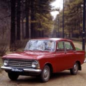 Punainen 1980-luvun Moskvitš-auto metsämaisemassa.