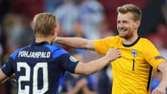 Segermålskytten Joel Pohjanpalo och straffräddaren Lukas Hradecky firar segern mot Danmark.