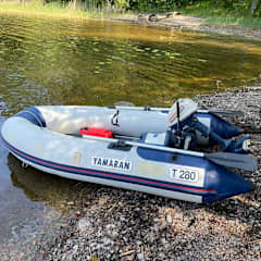 Маленькая резиновая лодка на берегу у воды.