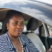 Kenialainen taksinkuljettaja Elizabeth Wanjiru auton ratissa Nairobin liikenneruuhkassa. 