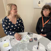 Kriisikeskusjohtaja Sari Huovinen ja kriisityöntekijä Raila Arpala istuvat pöydän ääressä. 