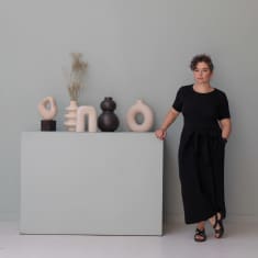 Toimittaja Nastja Krasilnikova seisoo taideteoksen vieressä.