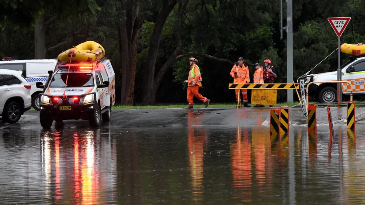Pelastustyöntekijöitä tulvaveden äärellä Australiassa.